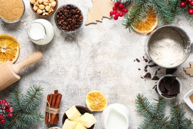 Yılbaşı pastası hazırlamak için farklı malzemelerden yapılmış çerçeve ve gri arka planda köknar dalları