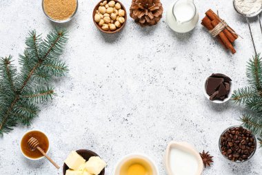 Noel pastası hazırlamak için farklı malzemelerden yapılmış çerçeve ve beyaz arka planda köknar dalları