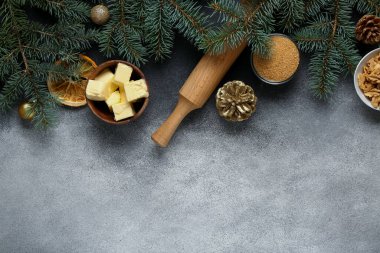 Gri arkaplanda Noel pastası ve köknar dalları hazırlamak için farklı malzemeler içeren güzel bir kompozisyon