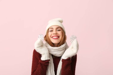 Pembe arka planda dekoratif kar taneleri olan güzel genç bir kadın.