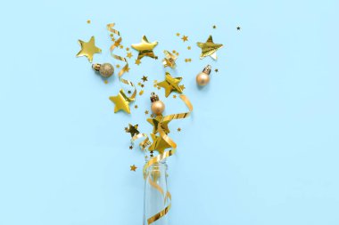 Mavi arka planda Noel dekoru olan şampanya şişesi.