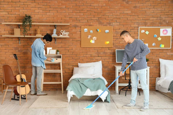 Male students cleaning in dorm room