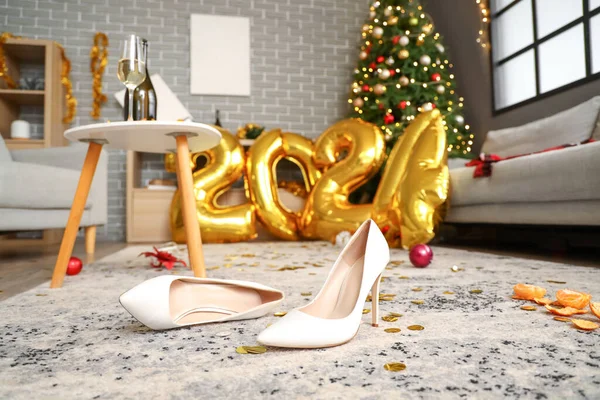 Heels with confetti in messy living room after New Year party, closeup