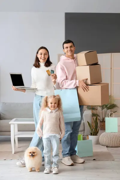 Happy family with laptop, credit cards and purchases from online store at home
