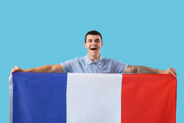 Young man with flag of France on blue background