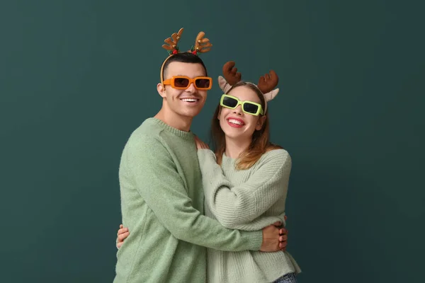 Beautiful Young Couple Reindeer Horns Sunglasses Green Background — Stock Photo, Image
