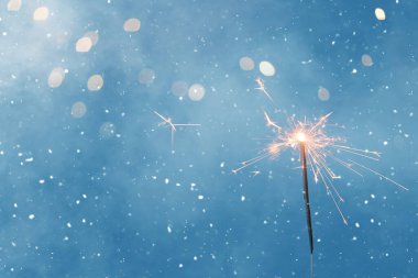 Bulanık ışıklarla mavi arka planda güzel bir Noel maytap 'ı