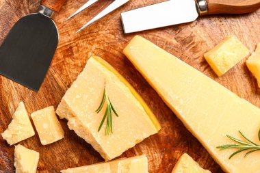 Ahşap zemin üzerinde lezzetli parmesan peyniri parçaları olan tabak.