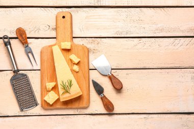 Hafif ahşap arka planda lezzetli parmesan peyniri parçaları olan tahta.