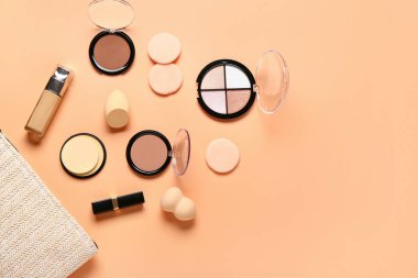 Makyaj ürünleri ve bej arka planda güzel çiçeklerle süslü şık bir makyaj çantası.