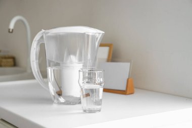 Su filtresi sürahisi ve mutfak tezgahında cam.