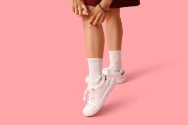 Pembe arka planda sivrisinek kovucu olan genç bir kadın.