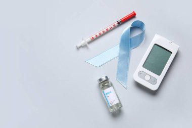 Işık arka planında insülin, şırınga ve glukometreyle farkındalık kurdelesi. Diyabet kavramı