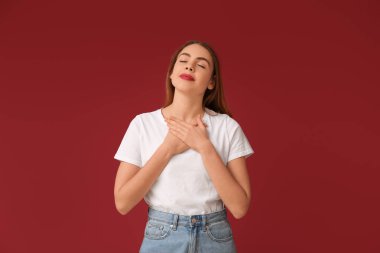 Güzel genç bir kadın kırmızı arka planda meditasyon yapıyor. Zen kavramı