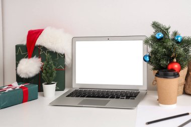 Boş dizüstü bilgisayarı, hediyeleri ve Noel ağacı olan işyeri