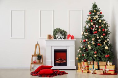 İçinde şömine ve Noel ağacı olan oturma odası.
