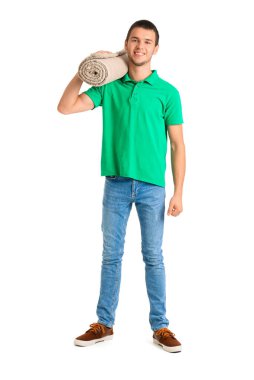 Genç yükleyici beyaz arka planda rulo halı taşıyor