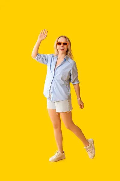 Νεαρή Όμορφη Γυναίκα Κουνώντας Χέρι Κίτρινο Φόντο — Φωτογραφία Αρχείου