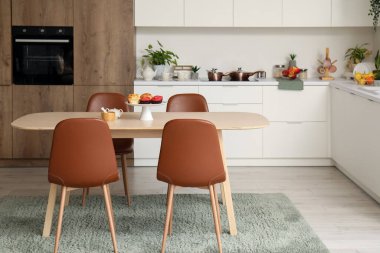 Ahşap yemek masası olan modern mutfağın içi.