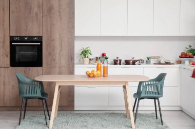 Ahşap yemek masası olan modern mutfağın içi.