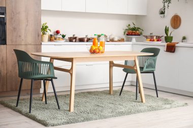 Ahşap yemek masası olan modern mutfağın içi.