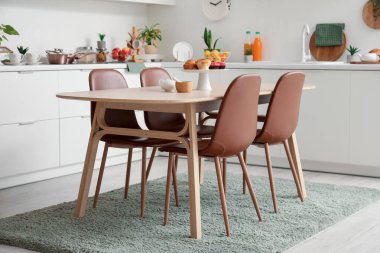 Ahşap yemek masası olan modern mutfağın içi.