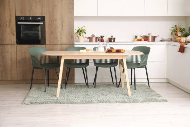 Ahşap yemek masası olan modern mutfağın içi.