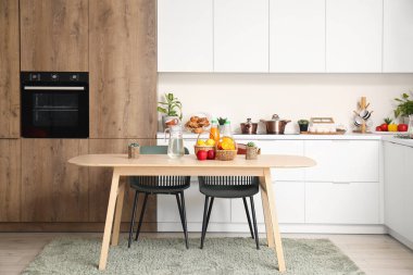 Ahşap yemek masası olan modern mutfağın içi.