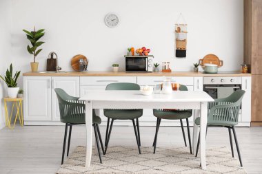 Modern mutfağın içinde yemek masasında süt ve şeker var.