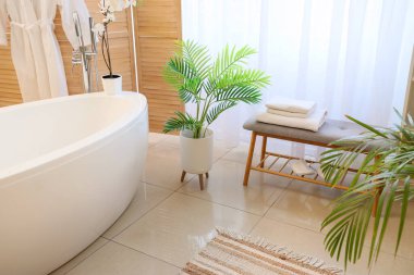 Banyonun içinde gri bank ve küvet var.