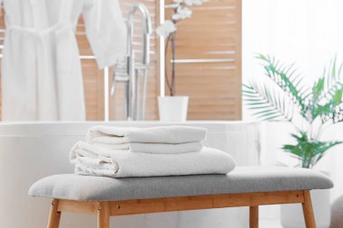 Banyonun içinde gri bank ve küvet var.