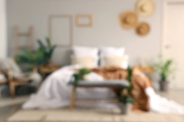 Rahat yatağı ve gri bankı olan rahat yatak odasının bulanık manzarası