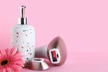 Eklenti, sabun ve pembe arka planda gerbera çiçeğiyle modern fotoepilatör.