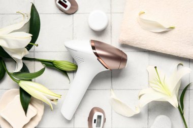 Eklentileri, banyo malzemeleri ve beyaz fayanslı zambak çiçekleri olan modern fotoepilatör.