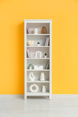 Turuncu duvarın yanındaki modern raf ünitesi