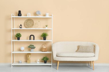 Modern raf ünitesi ve bej duvarın yanında beyaz kanepe