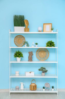Mavi duvarın yanındaki modern raf ünitesi
