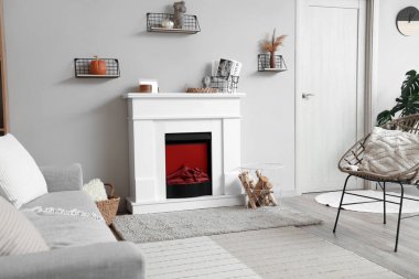 İçinde şöminesi, gri koltuğu ve sandalyesi olan modern oturma odası.