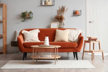 Kahverengi kanepesi ve ahşap sehpası olan modern oturma odasının içinde.