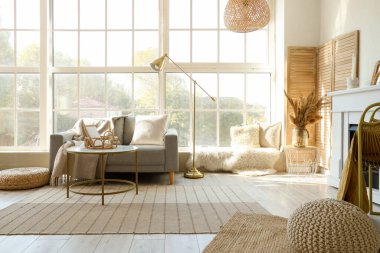 Gri kanepesi, sehpası ve şöminesi olan aydınlık oturma odasının içinde.