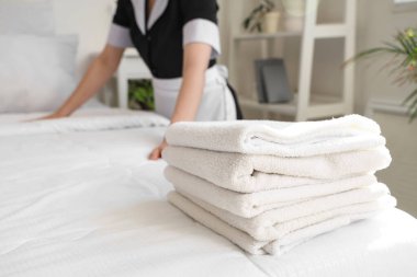 Oda hizmetçisi otel odasında yatak yapıyor, yakın plan.