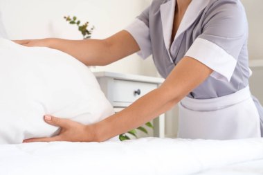 Oda hizmetçisi otel odasında yatak yapıyor, yakın plan.