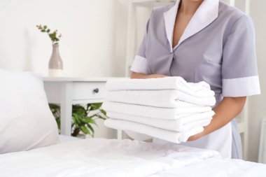 Oda hizmetçisi otel odasında yatak yapıyor, yakın plan.