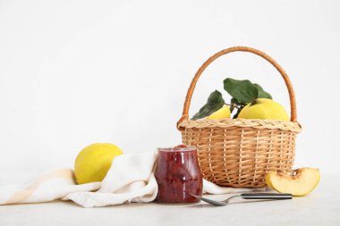 Kavanoz dolusu tatlı reçel ve sepet beyaz masada ayva meyveleri