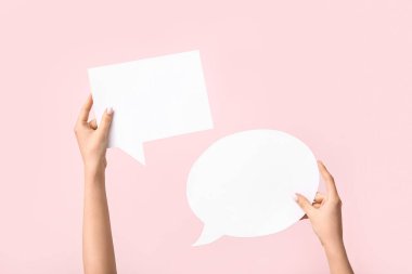 Pembe arka planda boş konuşma baloncukları olan kadın elleri