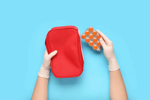 Doctor with pills and bag on blue background