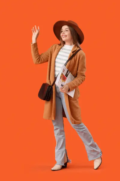 Jeune Femme Avec Journal Agitant Main Sur Fond Orange — Photo