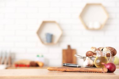 Taze mantarlı kolatör ve mutfak masasında pişirme aletleri.