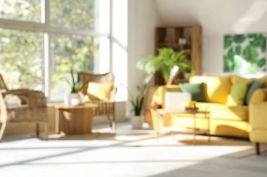 Sarı kanepesi ve çiçekleri olan modern oturma odasının bulanık görüntüsü