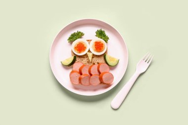 Yeşil arka planda baykuş şeklinde komik çocuk kahvaltısı tabağı.